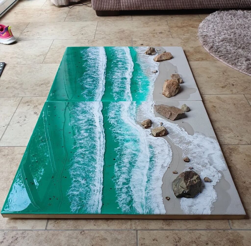 Ocean-inspired resin art with rocks on canvas.