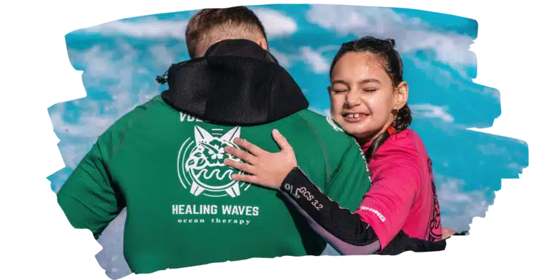 Child embracing ocean therapy instructor.